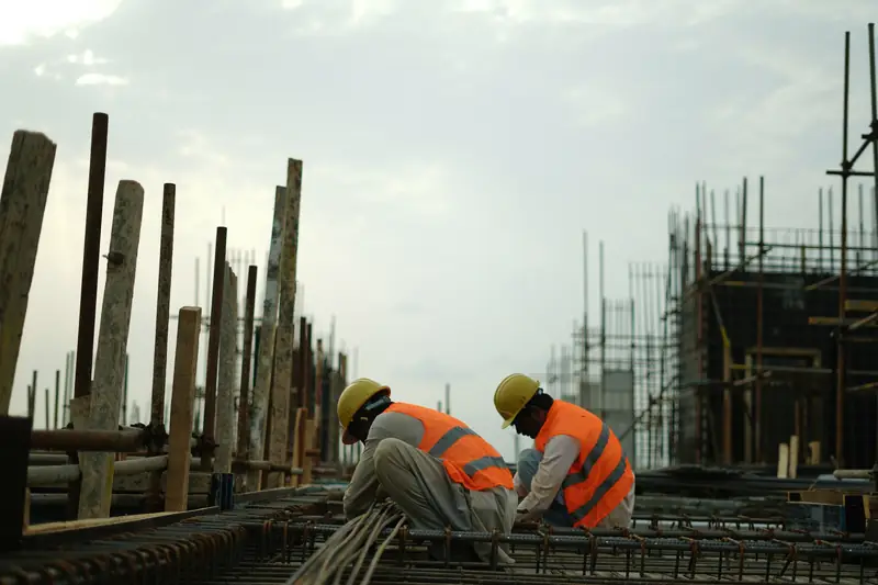 Site workers in hard hats and safety vests on a construction site