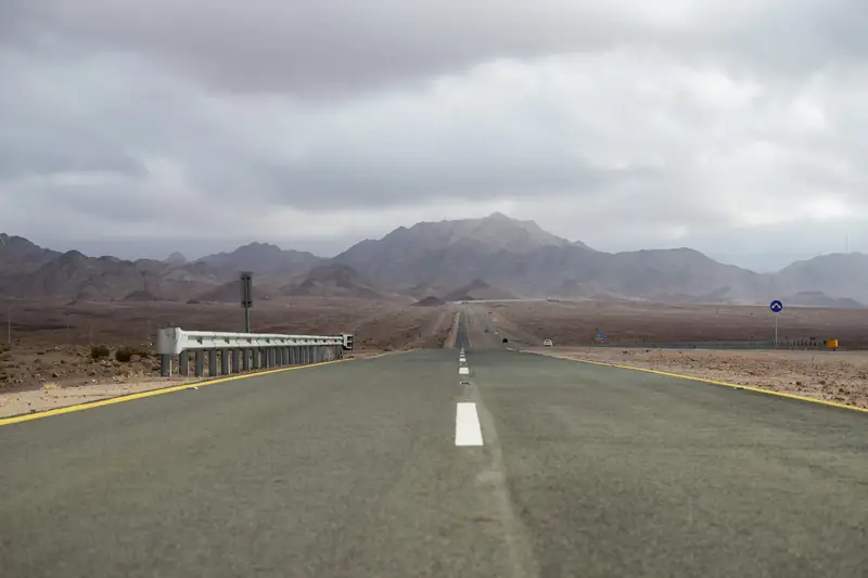 Empty desert highway stretching towards mountains