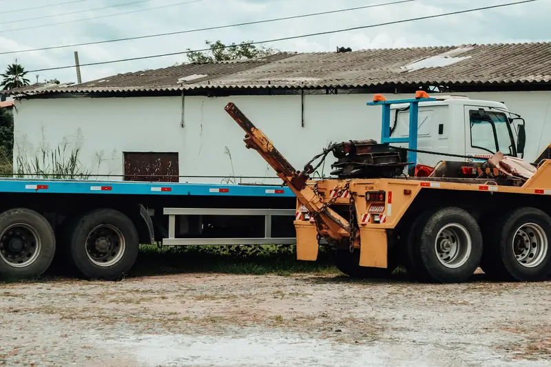 Heavy recovery truck with hydraulic boom parked at a yard