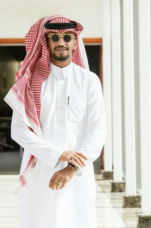Saudi man in a white thobe and red shemagh